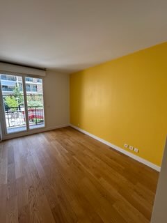 Pièce avec mur d'accent jaune vif et baie vitrée, parquet bois - Yvelines