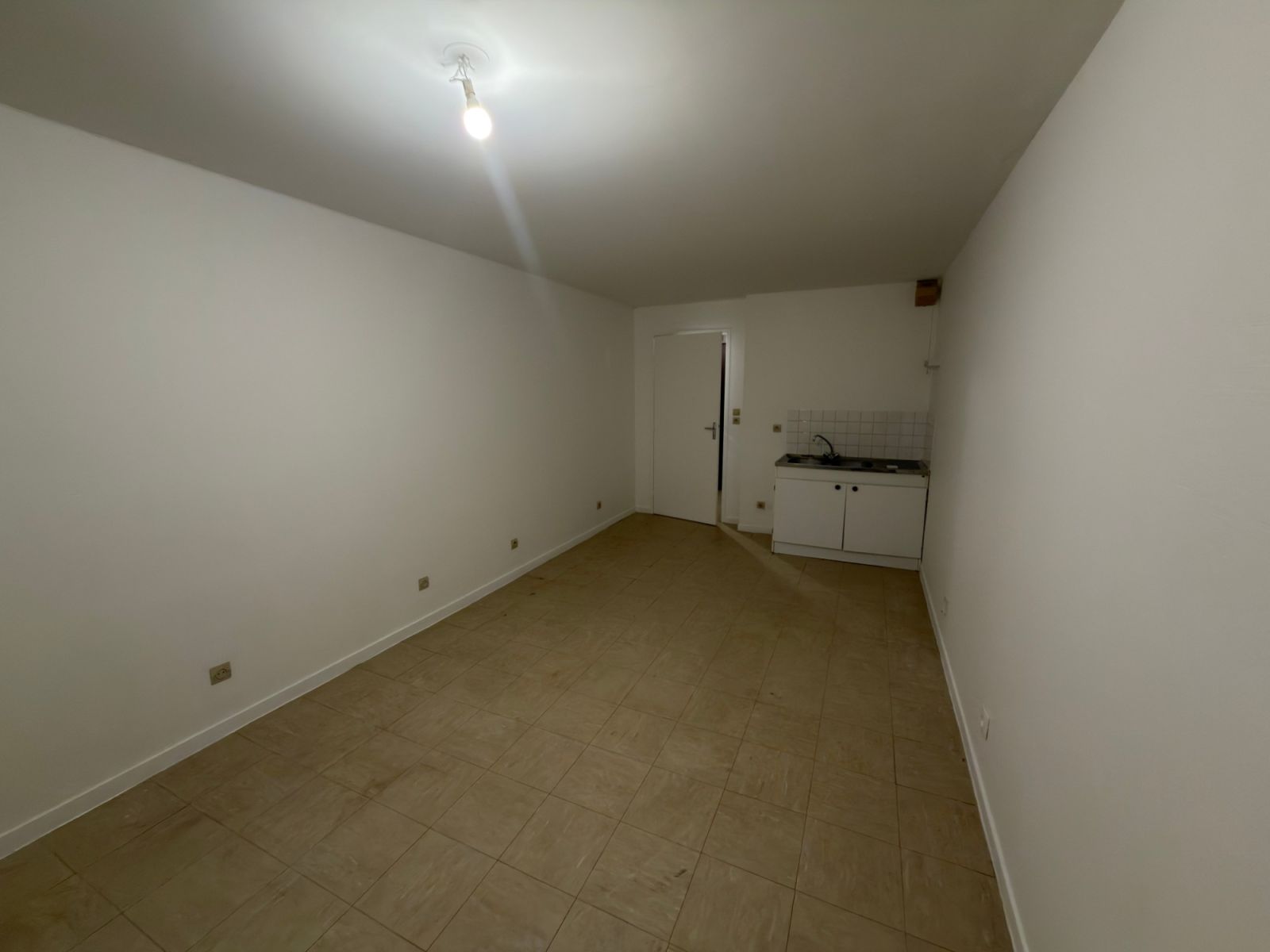 Studio après rénovation, murs et plafond blancs, coin cuisine - chantier Yvelines
