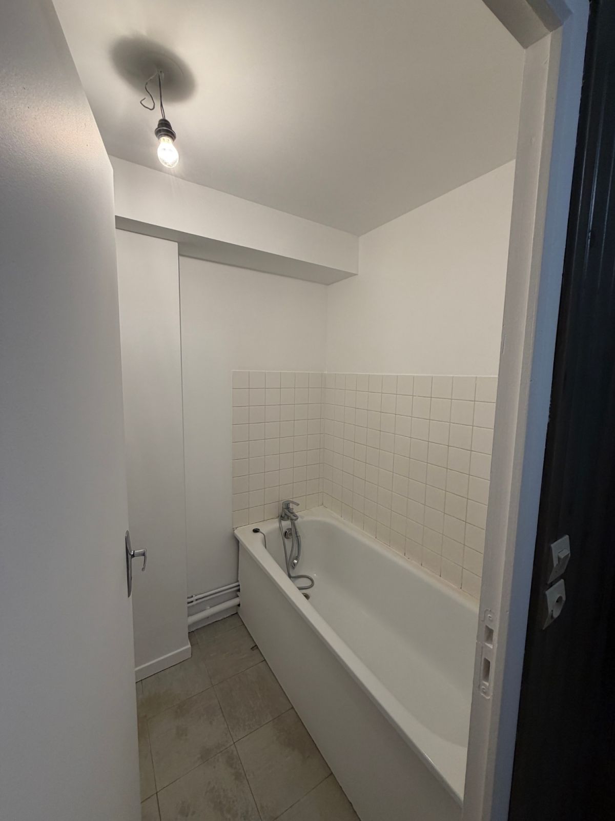Salle de bain du studio repeinte en blanc, baignoire et faïence - Yvelines