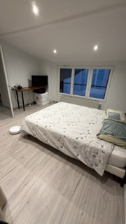Suite parentale après peinture, mur gris-bleu mat et niche éclairée - chantier Yvelines